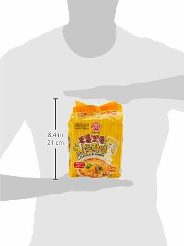 Person holding a package of cheese ramen with dimensions shown.